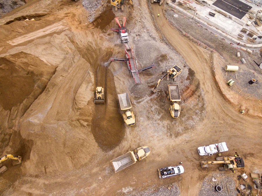 Fleet of yellow heavy plant excavators and trucks on an earthworks site